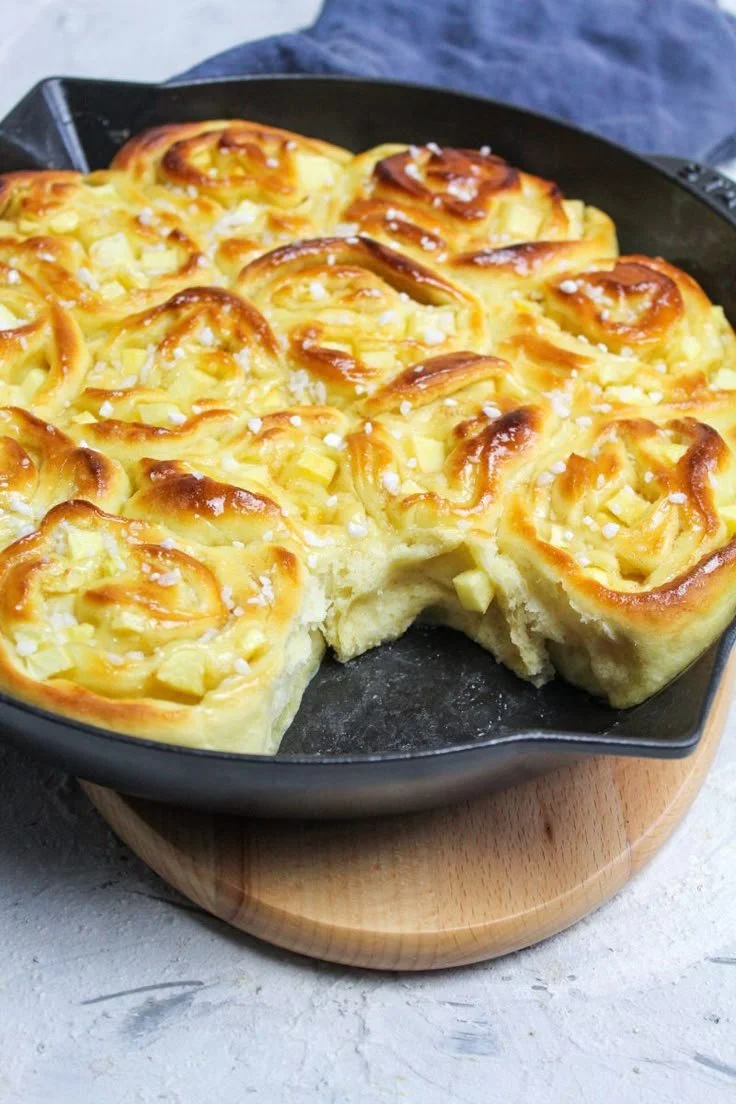 Apfel-Zimtschnecken frisch gebacken mit Äpfeln und Zimt auf einem Teller.