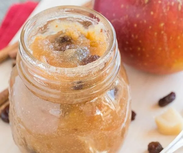 Hausgemachte Bratapfelmarmelade in einem Glas mit Äpfeln und Gewürzen