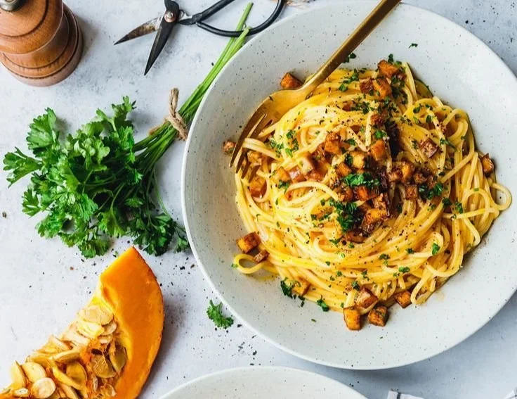 Vegane Carbonara mit Kürbis auf einem Teller serviert