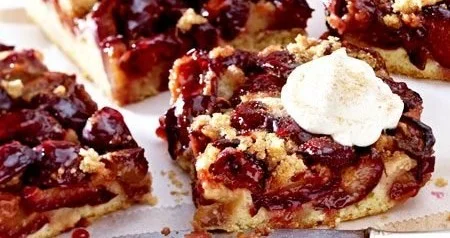 Pflaumenkuchen vom Blech mit Rührteig auf einem Tisch präsentiert