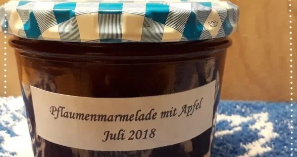 Pflaumenmarmelade in verschiedenen Variationen auf einem Holzbrett